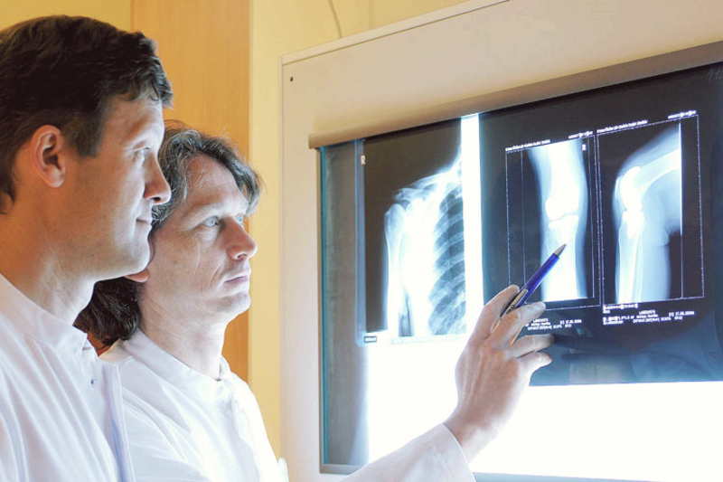 Abbildung: Prof. Dr. Verheyden analysiert ein Röntgenbild mit einem Kollegen